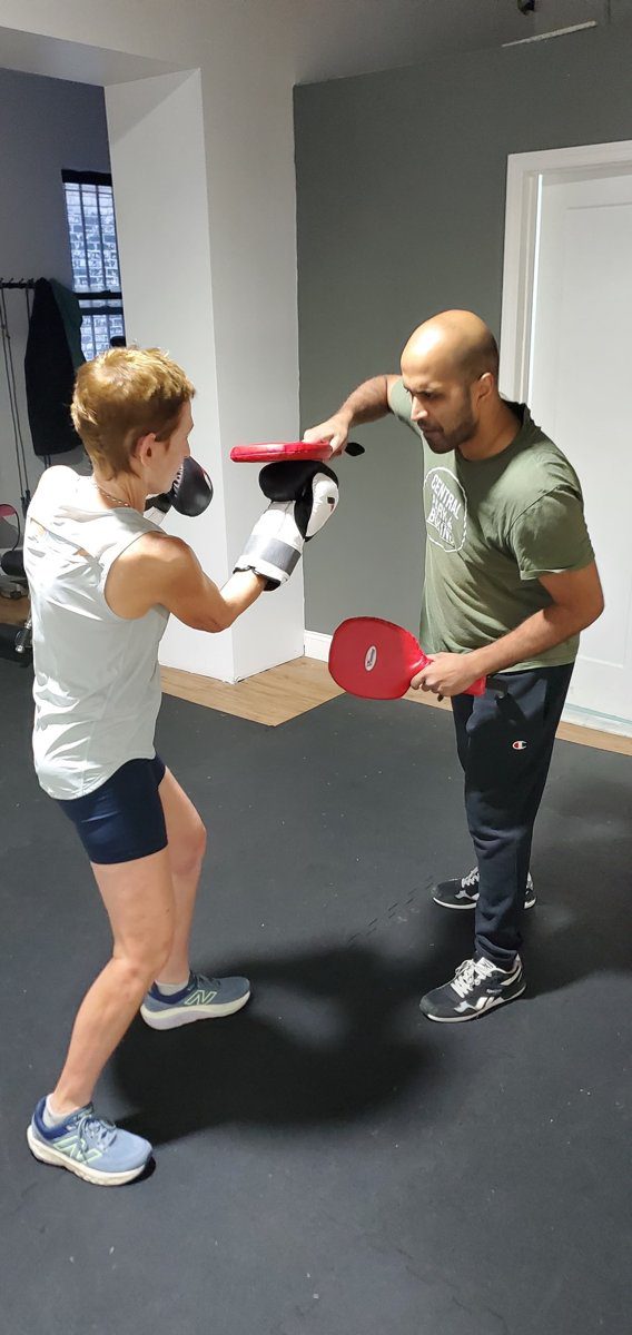 Woman training pad work with a coach